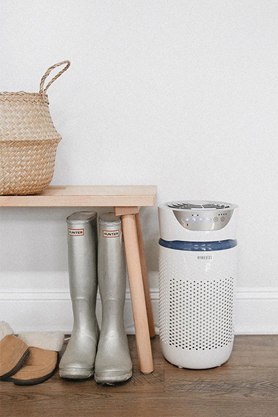 Homedics TotalClean 5-in-1 UV-C Medium Room Air Purifier sits next to shoe stand in home.