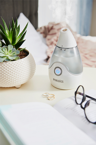Homedics personal humidifier on table next to plant and glasses