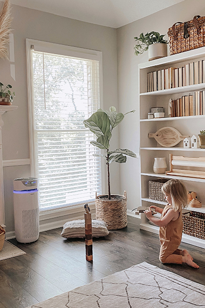 Child plays in a large, brightly lit room near a Homedics TotalClean 5-in-1 UV-C Deluxe Large Room Air Purifier.