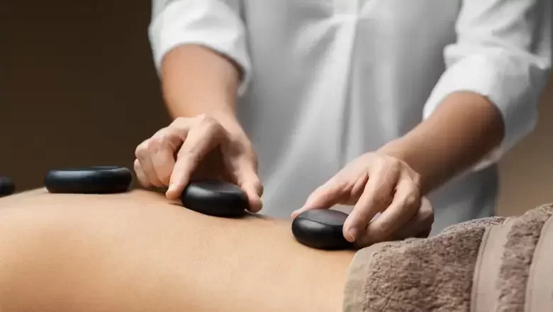 Person receives a hot stone massage from a professional masseuse