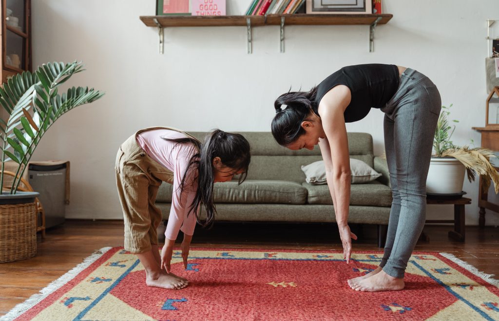 Woman and child do a standing hamstring strech