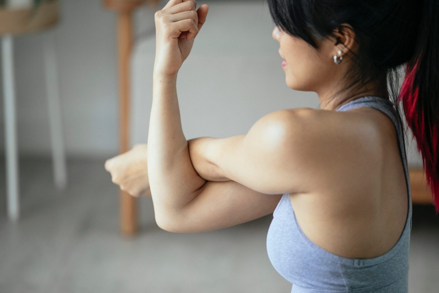 Side view of woman doing arm and shoulder stretches